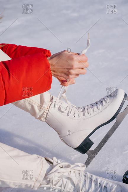 Woman sitting on snow and changing boots