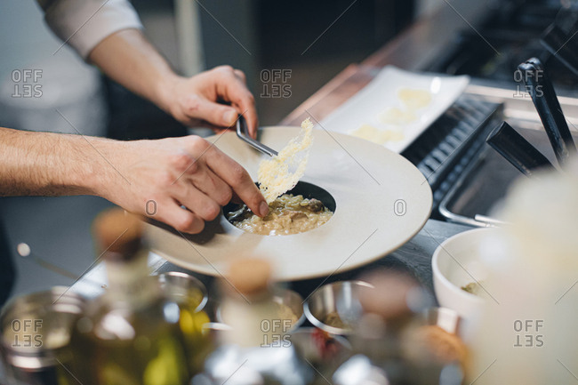 Chef preparing a dish with cheese in an Italian restaurant
