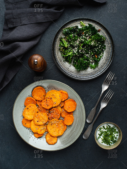 Sweet potato slices baked in oven served with warm kale salad
