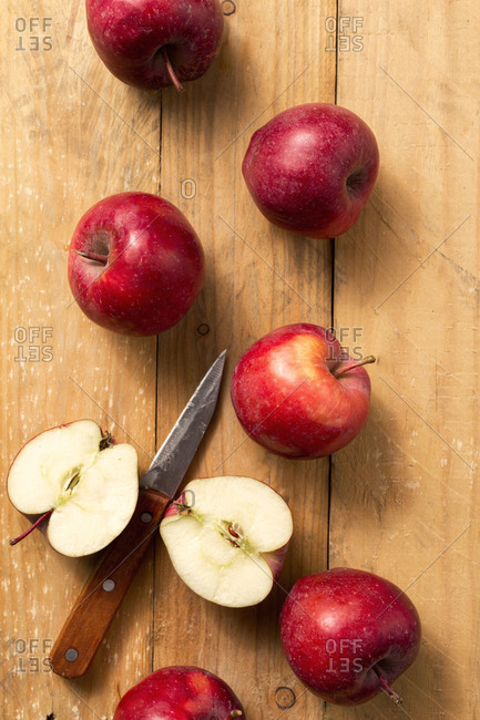 Whole and slices of red apples on wooden table