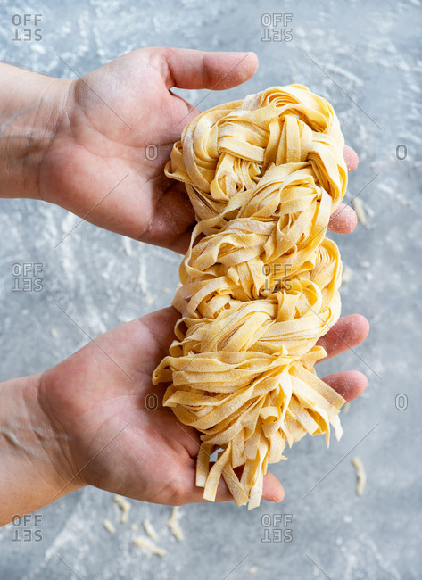 Fresh egg pasta in the palm of hands from above