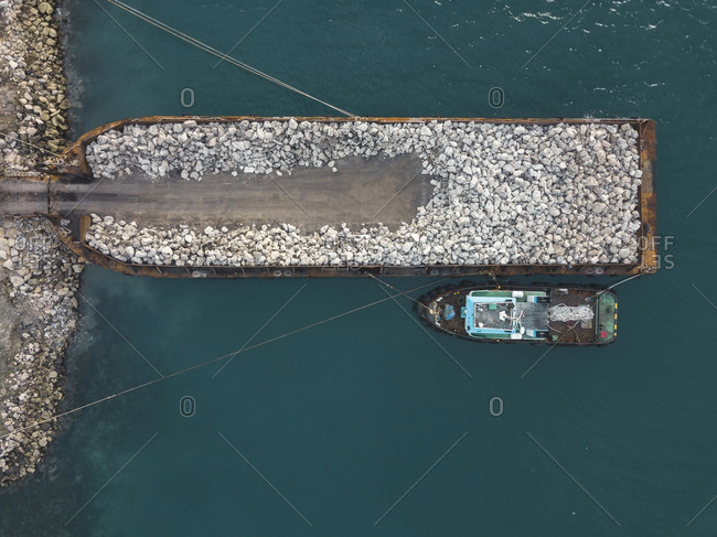 Aerial view of large barge with stones near sumbawa island coastline