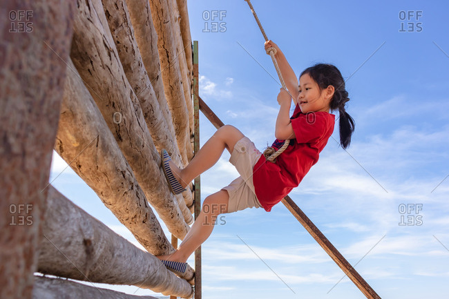 A girl is climbing an adventure toy.