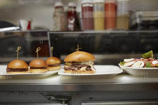 Burgers served in plates on kitchen counter