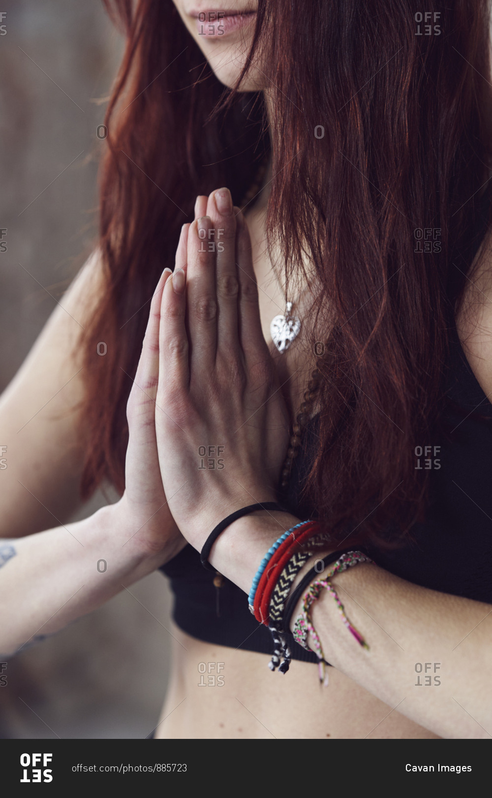 Close up of female hands in yoga pose by the brick wall