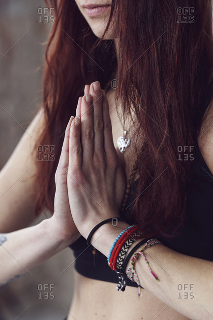 Close up of female hands in yoga pose by the brick wall