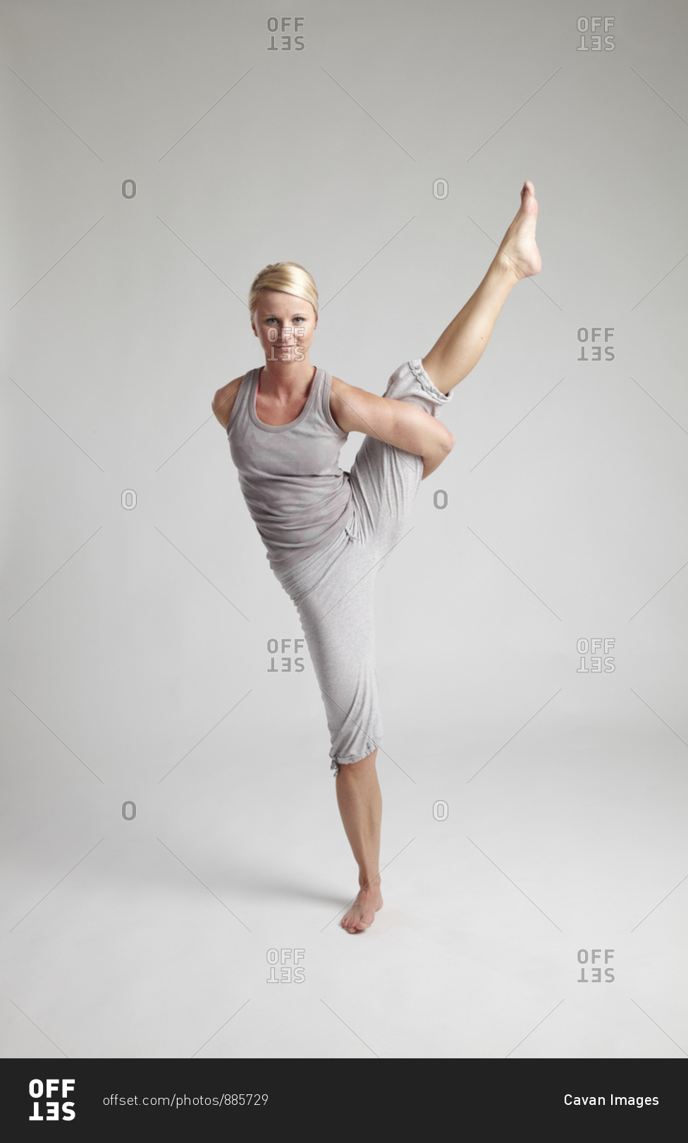 Young female doing yoga pose on clean background.