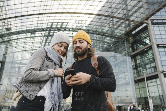 Young couple using a smartphone at the central station- Berlin- Germany
