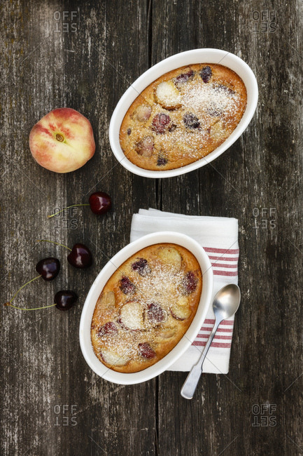 Bowls of gluten free homemade clafoutis with cherries- peaches and almonds