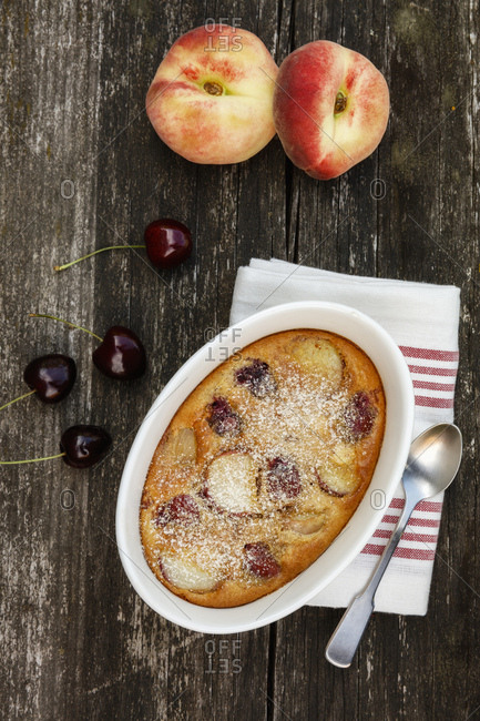 Bowl of gluten free homemade clafoutis with cherries- peaches and almonds