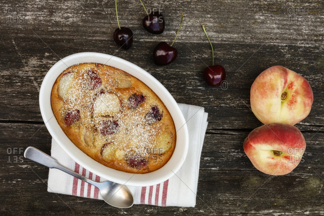 Bowl of gluten free homemade clafoutis with cherries- peaches and almonds