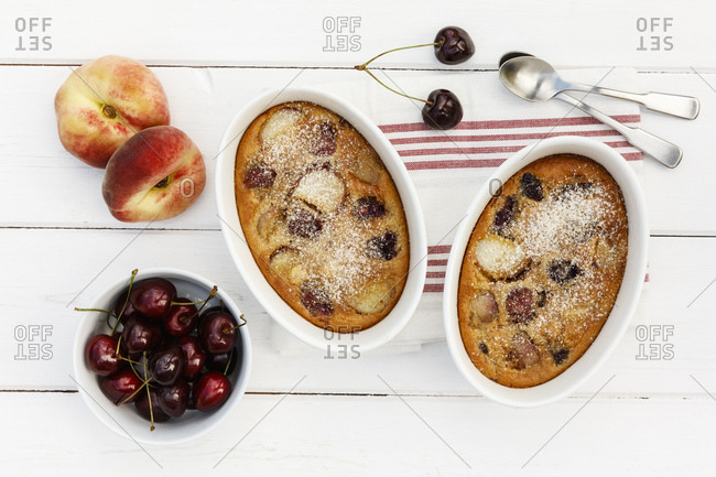 Bowls of gluten free homemade clafoutis with cherries- peaches and almonds
