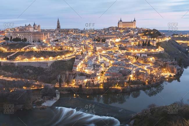 Spain- Province of Toledo- Toledo- Tagus river and illuminated city at dawn