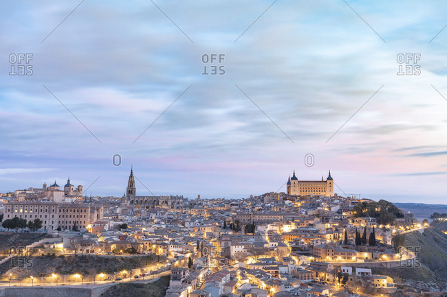 Spain- Province of Toledo- Toledo- Clouds over illuminated city at dawn