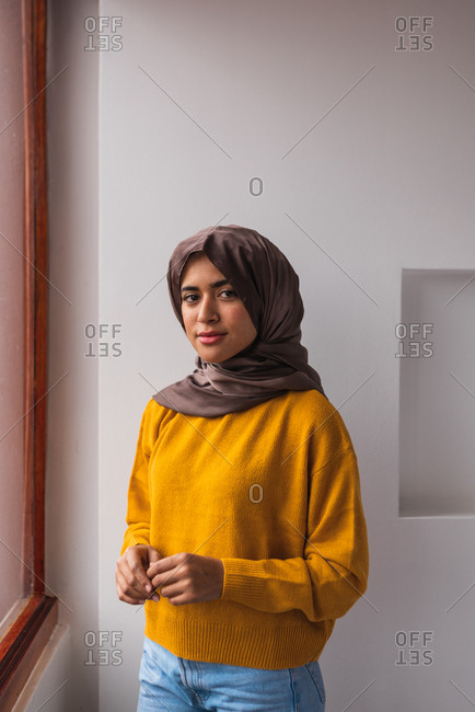 Portrait of a Muslim girl wearing hijab and a yellow sweater and jeans