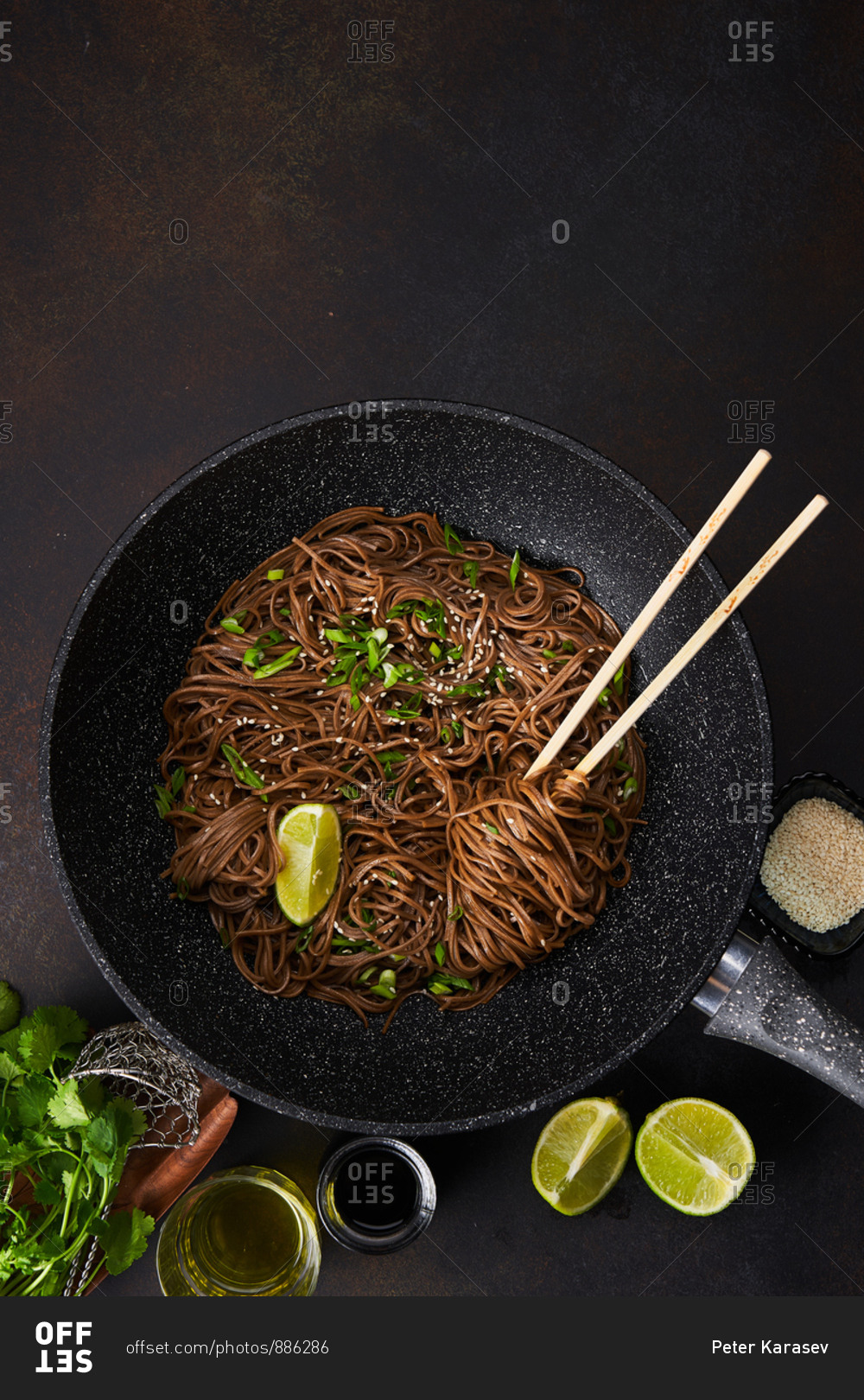 Overhead view of sesame noodles in a wok with chopsticks