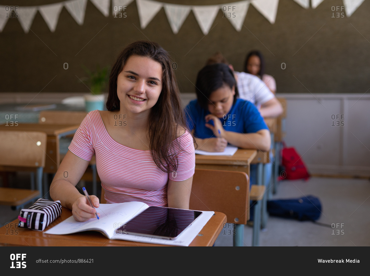 Teenage Girl Sitting At Desk Drawing In Sketchbook Portrait High