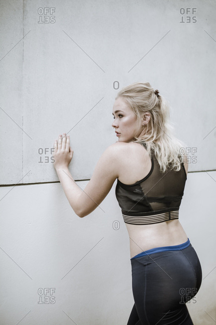 Young blond woman prepares herself  with warm-up exercises for sport