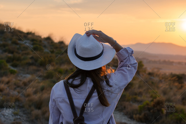 Young woman is walking on the mountain with a hat and her backpack. Travel, adventure, lifestyle