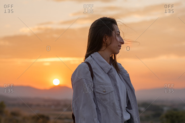 Young adventurer woman on a mountain at sunset. Lifestyle concept, portrait