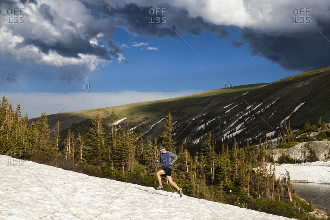 Man trail runs on snow in Indian Peaks Wilderness, Colorado