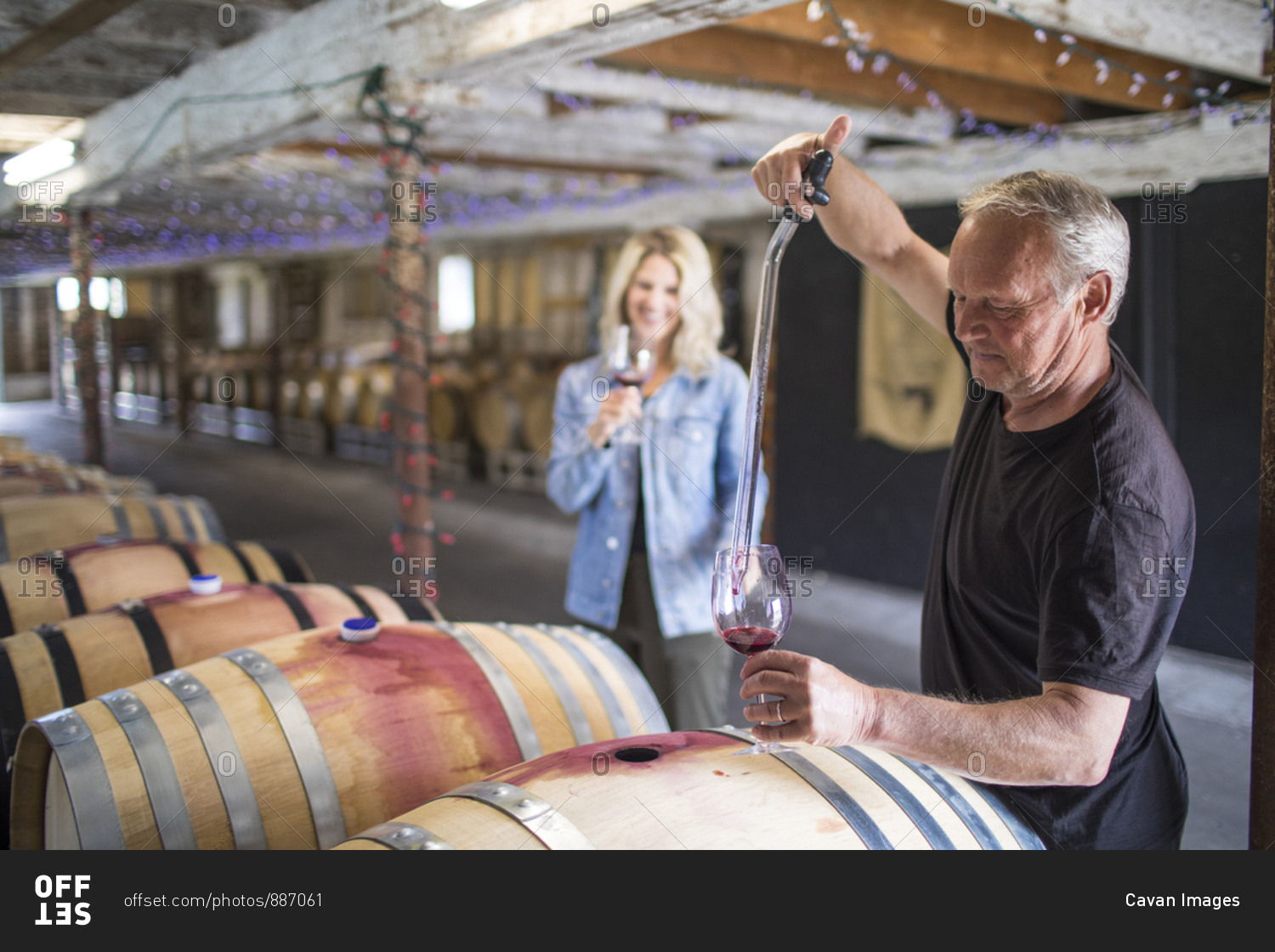 sommelier extracts wine from a barrel during a wine tour.