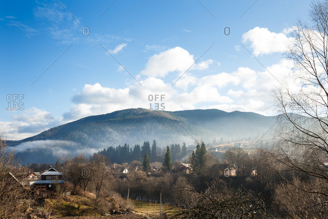 The wonderful landscape of the foggy mountain and forest and the small village under it