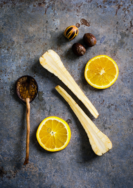 Sliced lemons and carrots on gray background