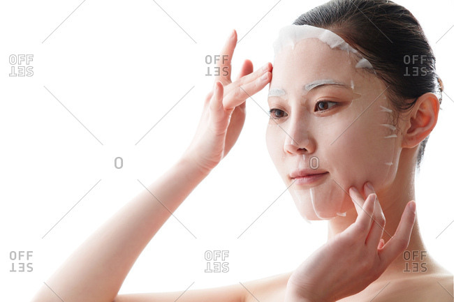 Young woman applies a facial mask