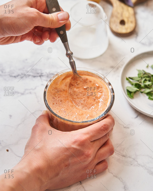 Chef mixing cream and sauce on marble surface