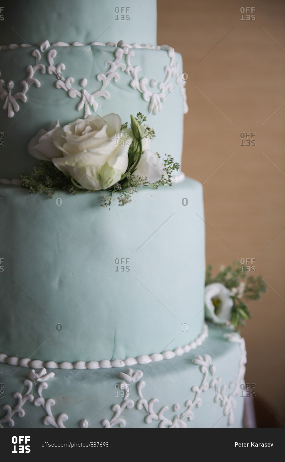 Detail of a beautiful blue pastel wedding cake with white roses