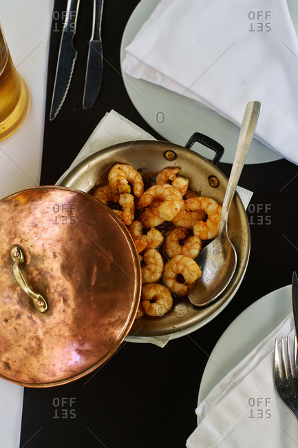 Fried spicy shrimp served in a restaurant with a glass of beer. Portuguese cuisine