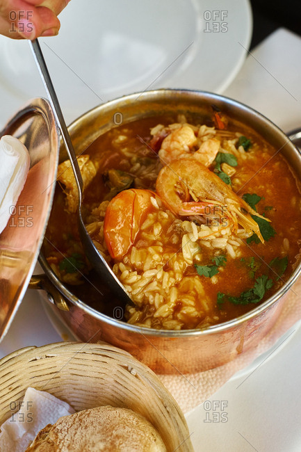 Saffron rice with seafood in a copper pot. Restaurant food for two people. Top view. Portuguese cuisine