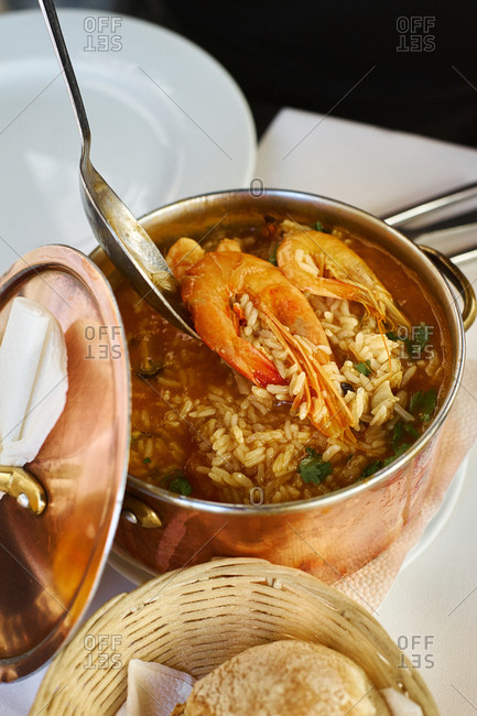 Saffron rice with seafood in a copper pot. Restaurant food for two people. Top view. Portuguese cuisine