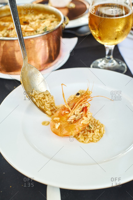 Saffron rice with seafood in a copper pot. Restaurant food for two people. Top view. Portuguese cuisine