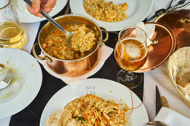 Saffron rice with seafood in a copper pot. Restaurant food for two people. Top view. Portuguese cuisine