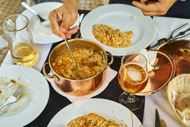 Saffron rice with seafood in a copper pot. Restaurant food for two people. Top view. Portuguese cuisine