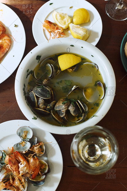 Cooked clams and shrimp with white wine, butter, lemon and parsley. Summer lunch at home. Portuguese cuisine. Top view