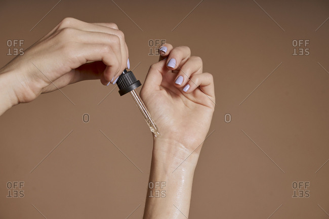 A woman testing cosmetic oil on her skin