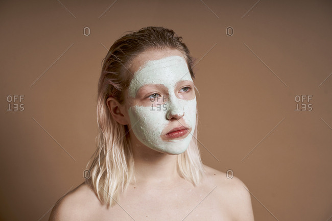Woman using face mask for skin cleansing and moisturizing