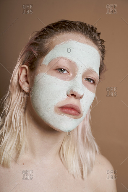 Woman using face mask for skin cleansing and moisturizing