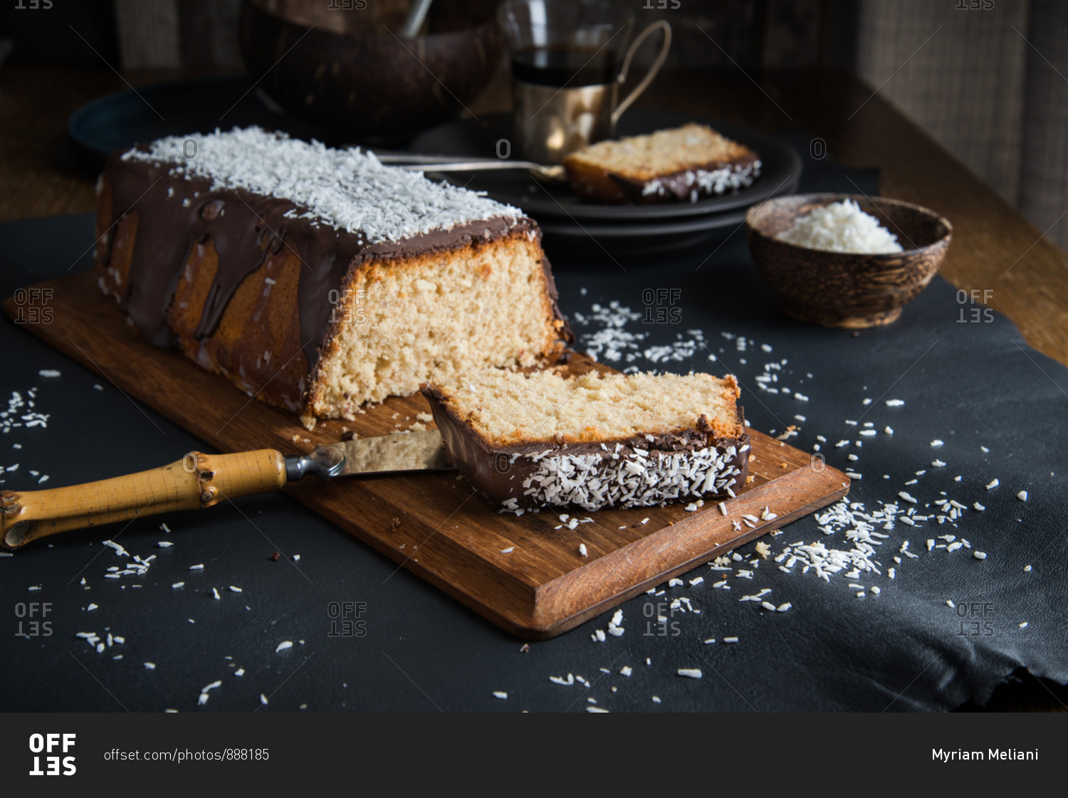 A coconut pound cake glazed with chocolate and coconut rasp sliced and ready to be shared