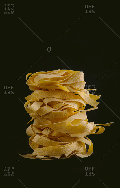 Dried pappardelle on black background