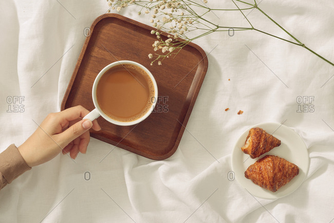 Woman's hands holding worm coffee cup. View from top