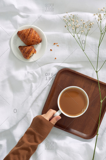 Female hand hold coffee cup. Top view.