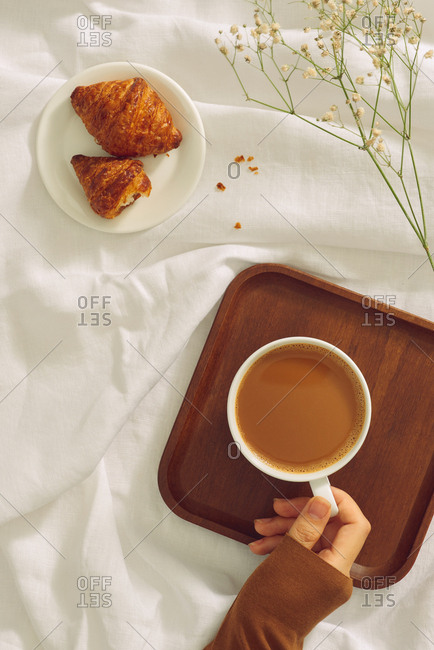Female hand hold coffee cup. Top view.