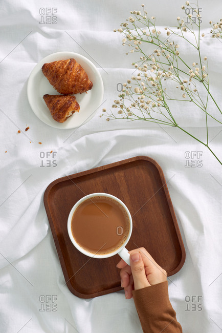 Woman's hands holding worm coffee cup. View from top