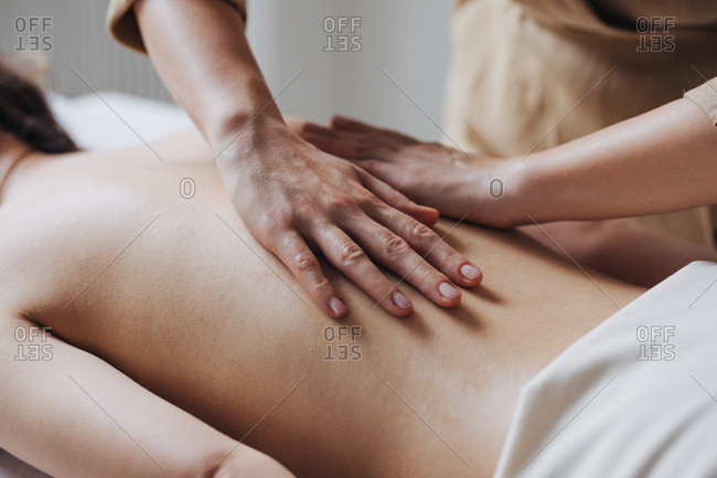 Hands of unrecognizable woman masseuse doing back massage.