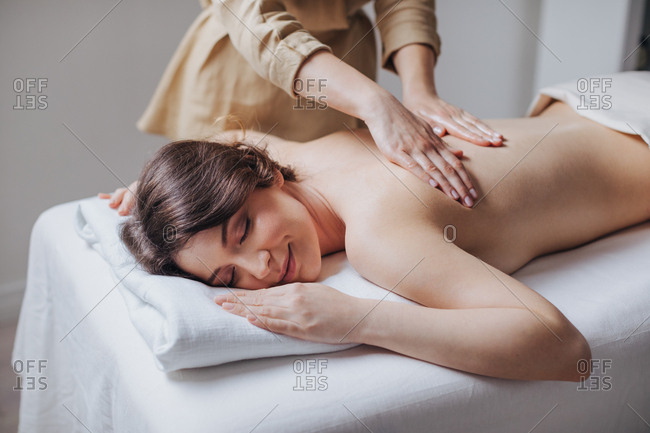 Pretty caucasian woman enjoying back massage at spa salon.