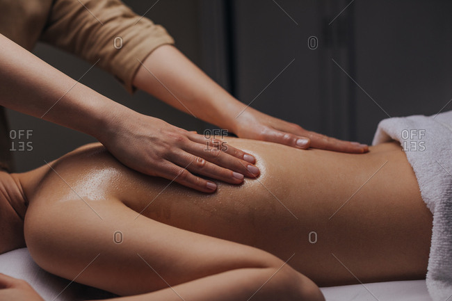 Close up of hands of unrecognizable woman masseuse doing back massage.